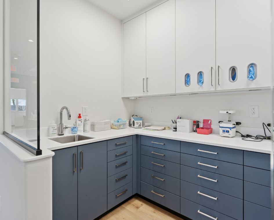 A luxurious kitchen featuring elegant blue cabinets and pristine white countertops, designed by Commercial Custom Solutions.

