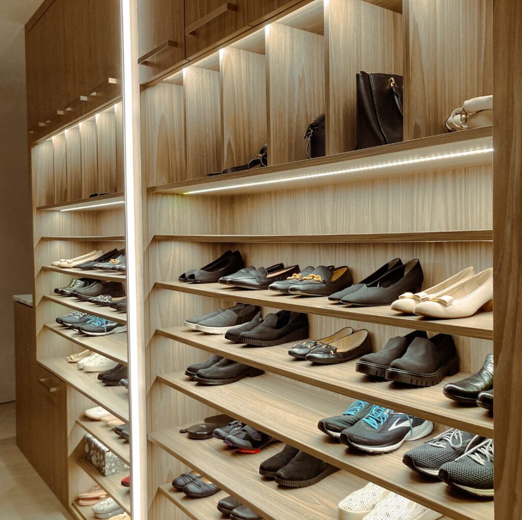 A well-organized closet filled with various shoes neatly arranged on tailored shelves for optimal storage.

