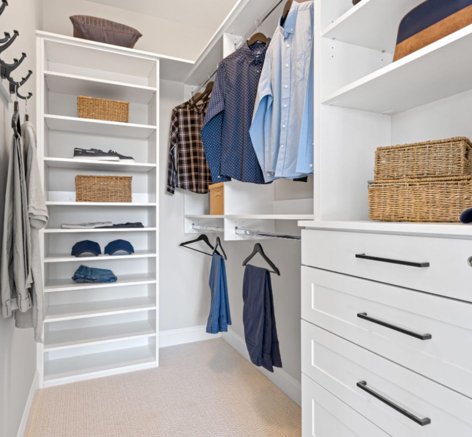 A spacious walk-in closet featuring unique white cabinets and drawers for stylish and efficient storage solutions.

