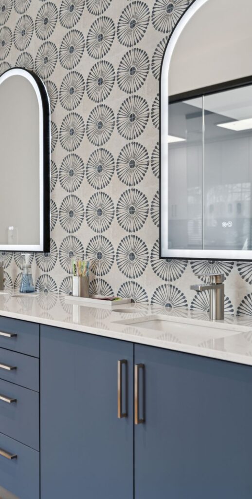 A luxurious bathroom featuring elegant blue cabinets and a stylish mirror, designed by your wholesale wtorage partners, Top Shelf Closets.